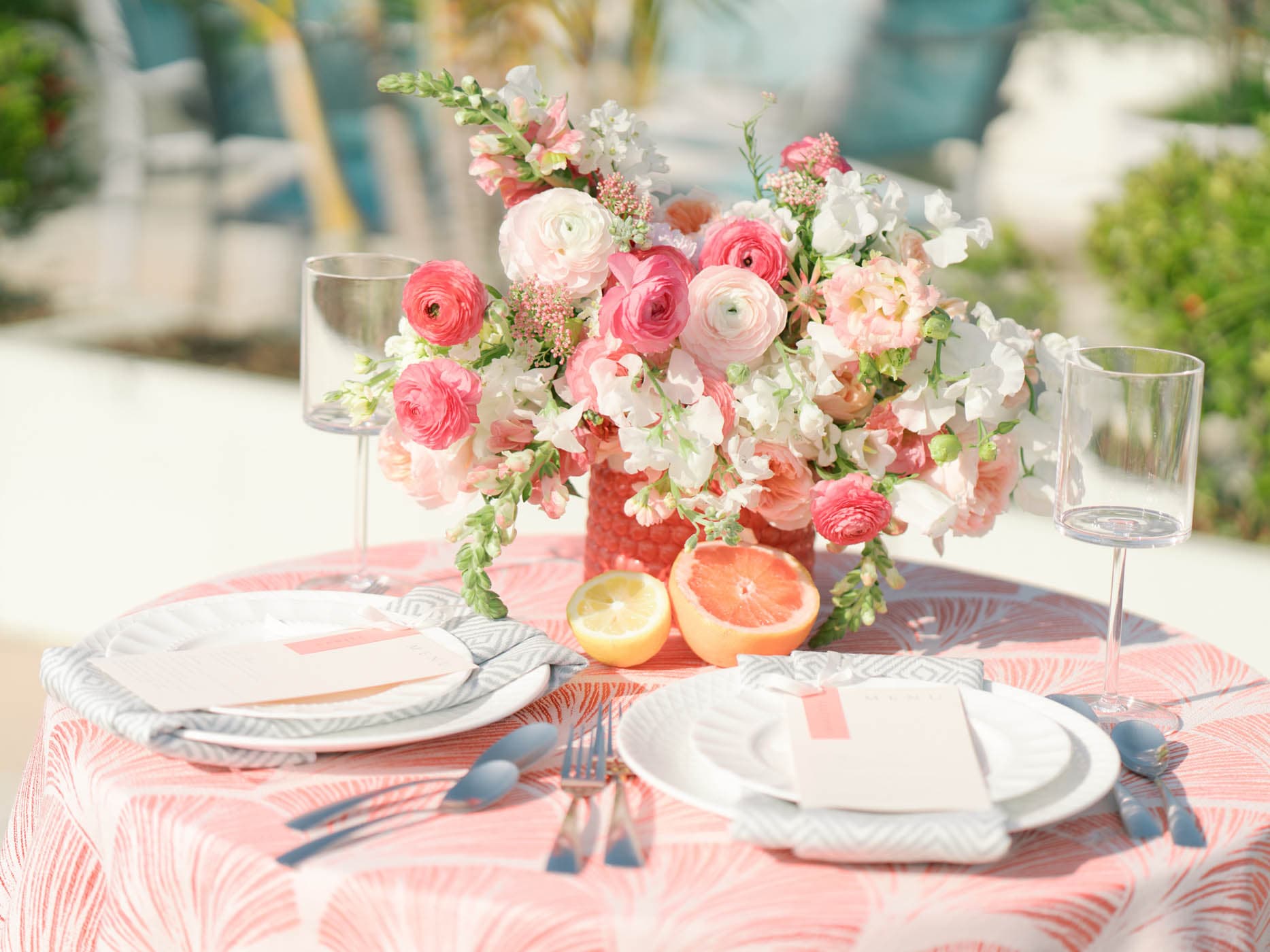 A table setting with bouquets of pink and white flowers set up for an event