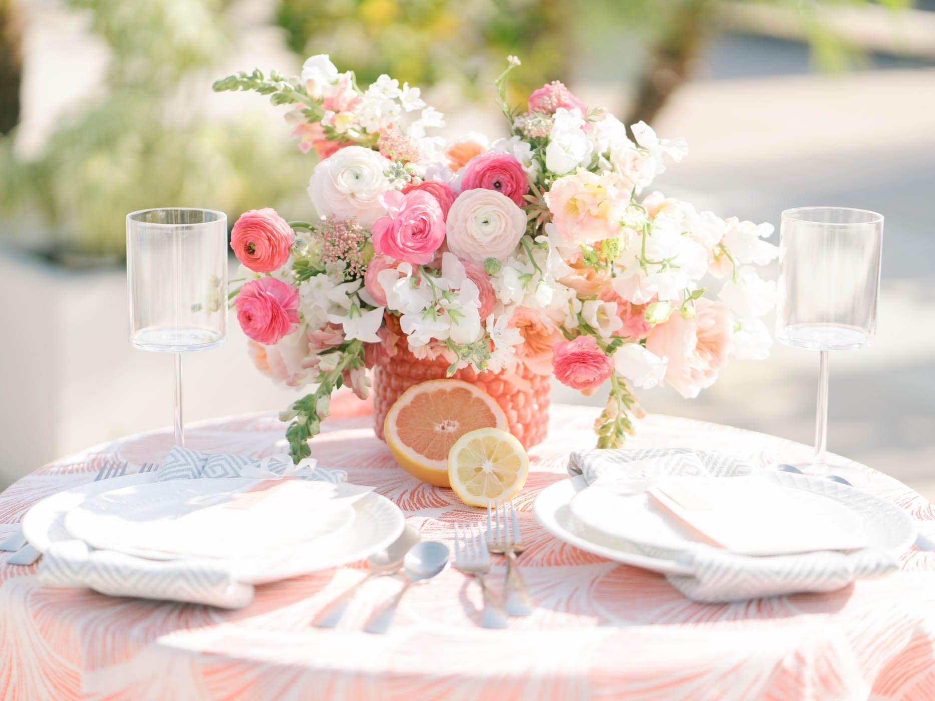 A table setting with bouquets of flowers set up for an event