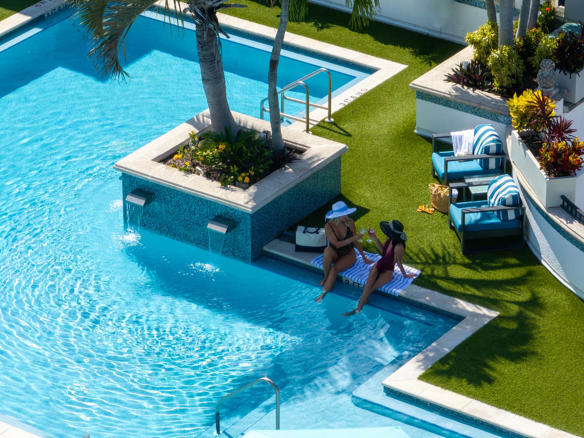 Couple in the pool surrounded by palms at Inn on Fifth in Naples, Florida