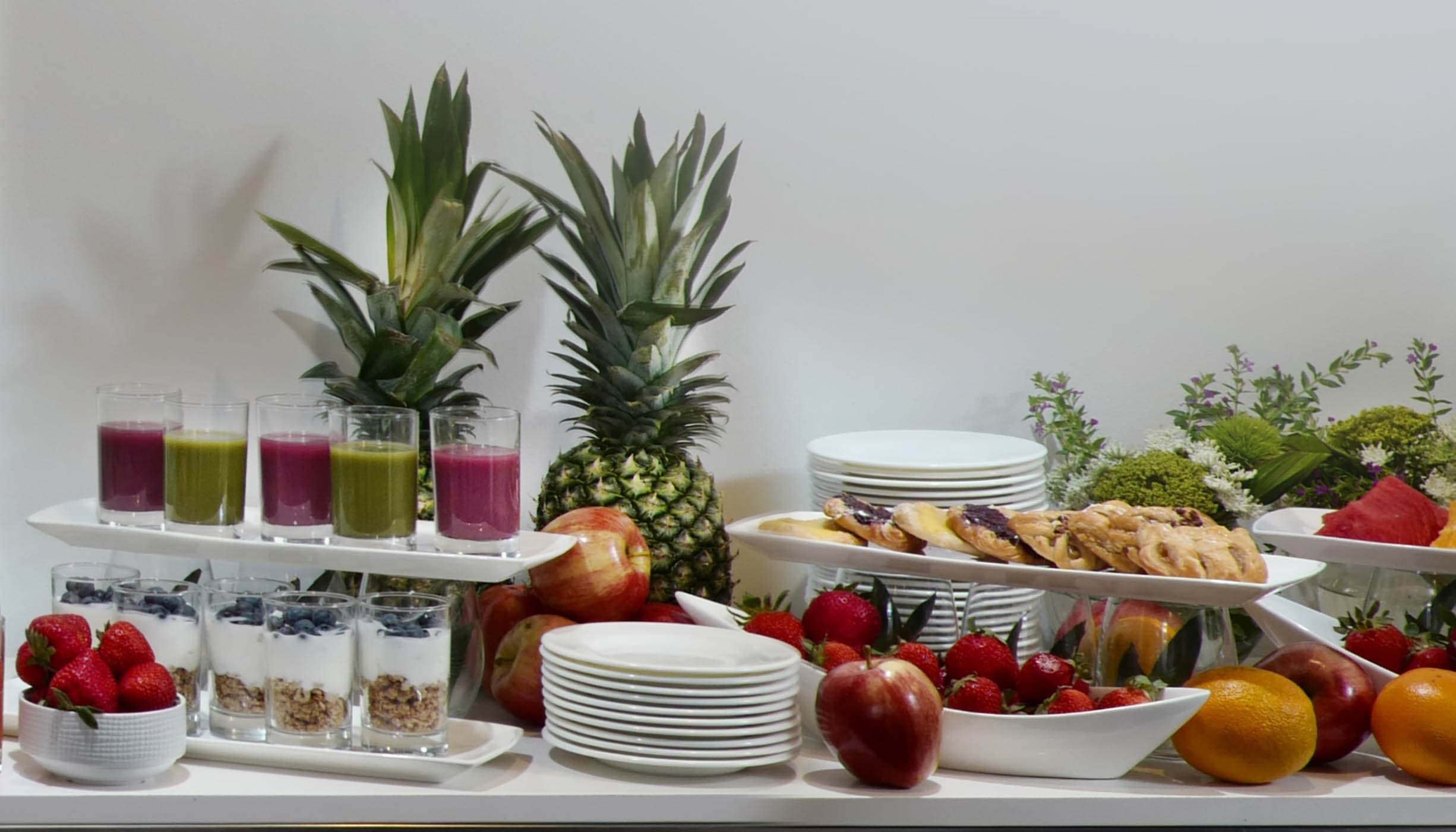 A spread of fruit, fruit juices and yogurt and berries