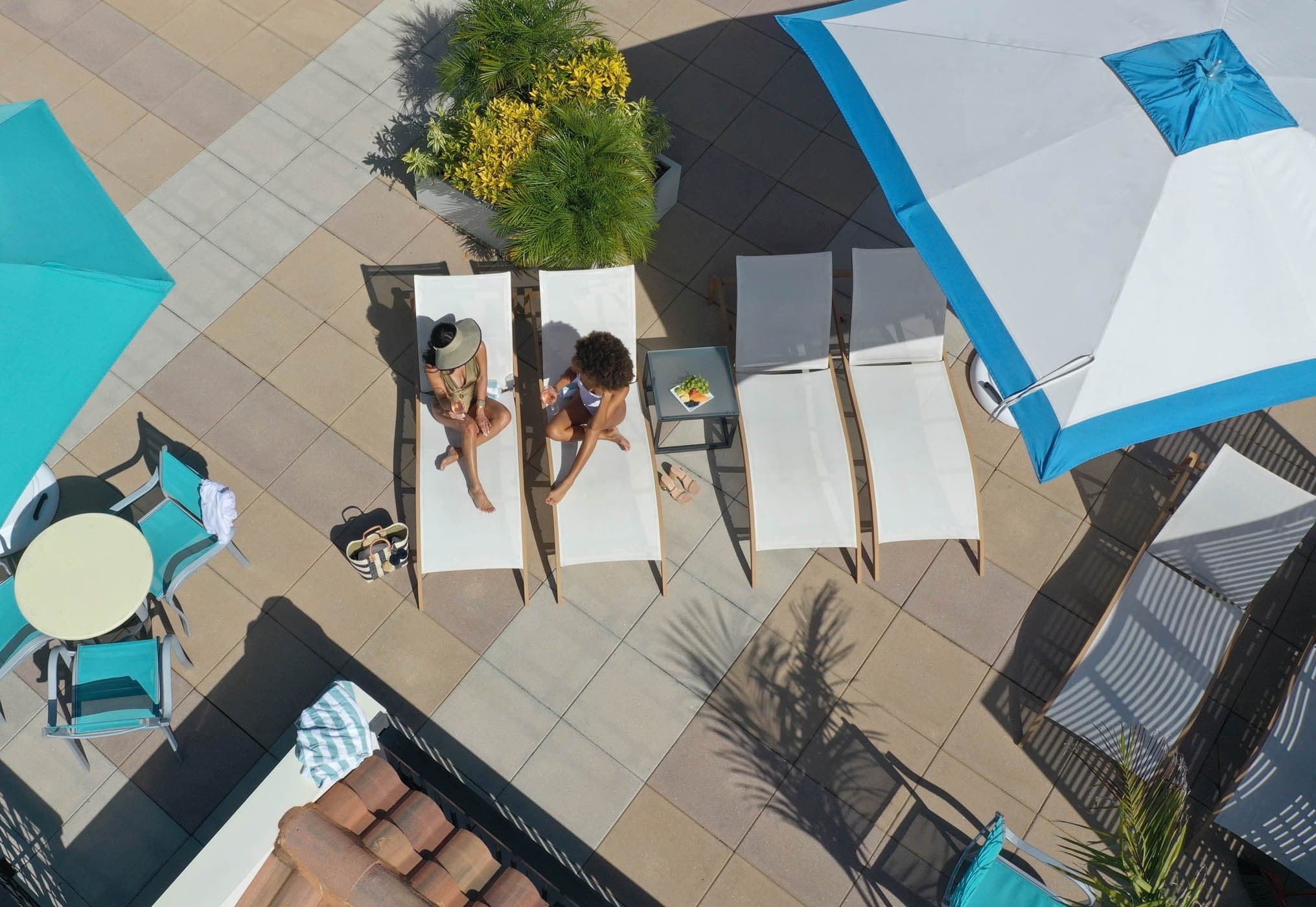 2 woman having drinks lounging by the pool at Inn on Fifth