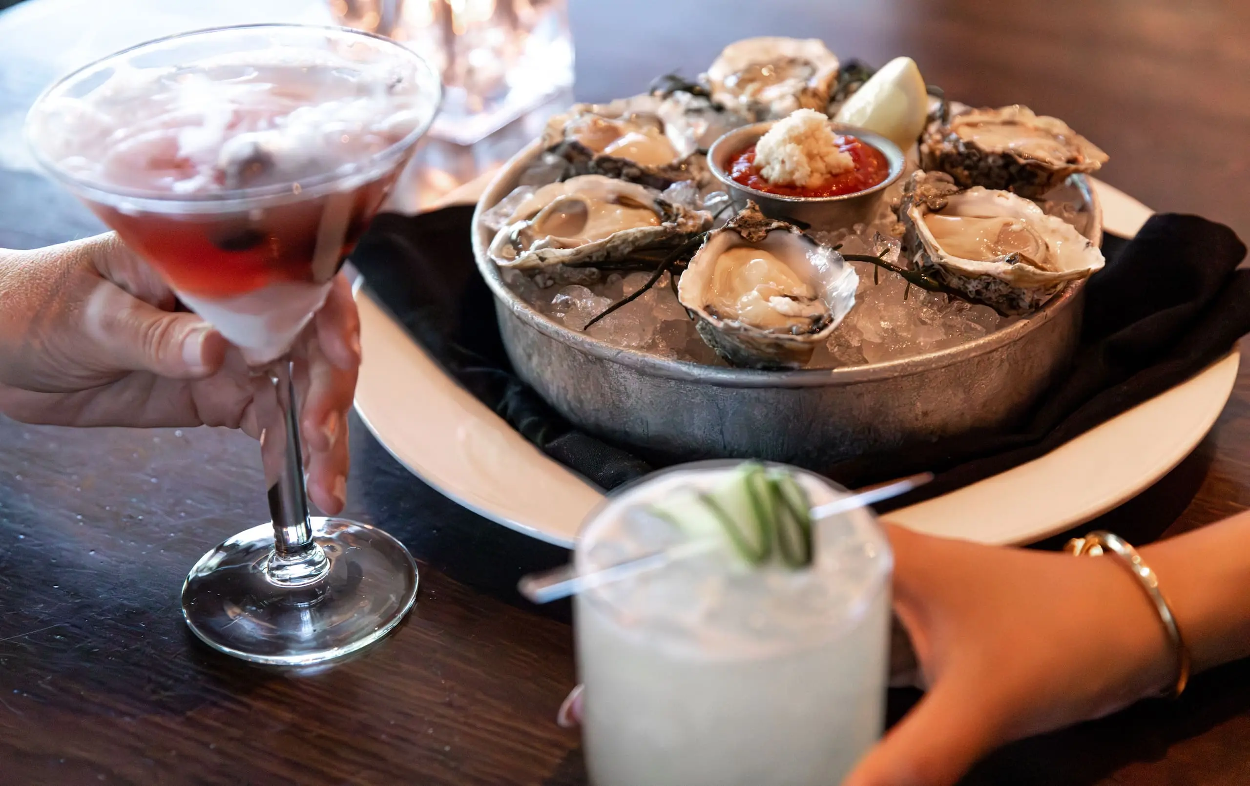 Two cocktails and oysters on a table at Inn on Fifth