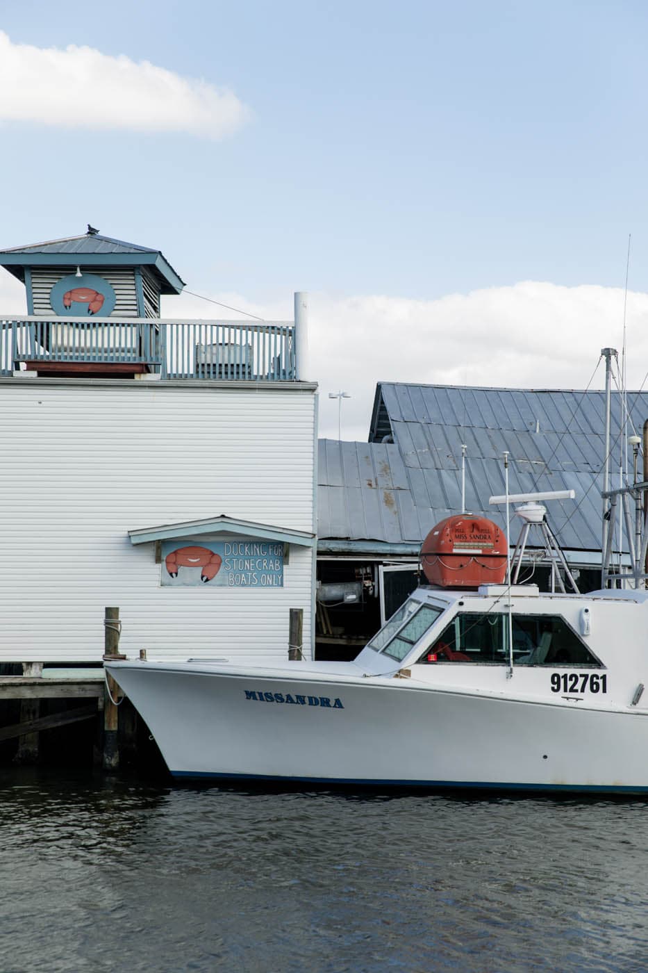 A boat docked at a waterfront marina in Naples, Florida