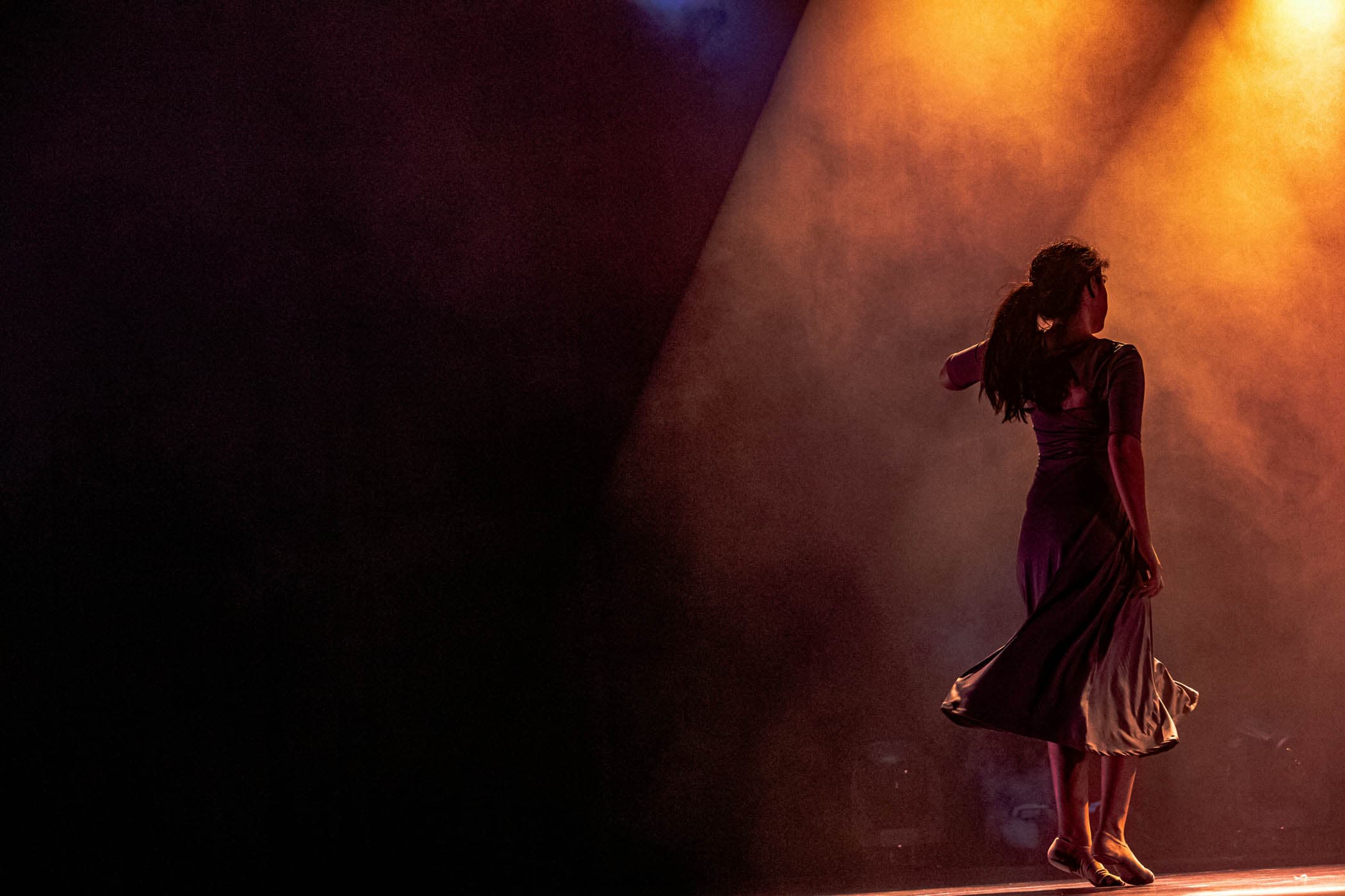 Dancer performing under stage lights at a theater in Naples, Florida