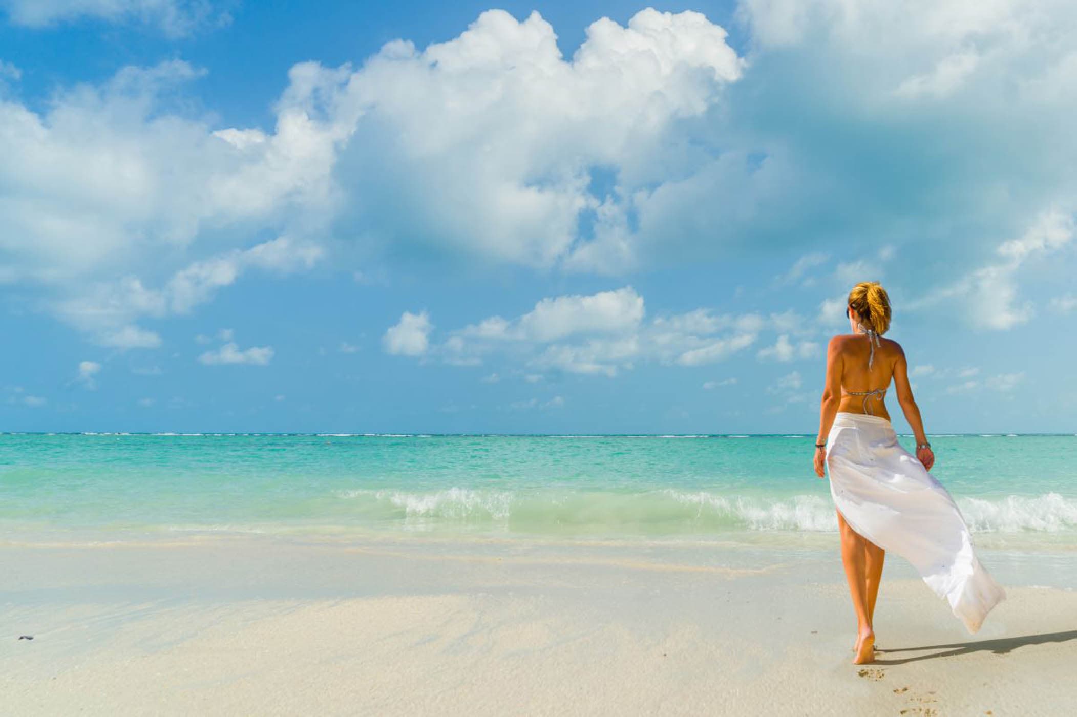 Woman on the white sand beach near Inn on Fifth in Naples, Florida