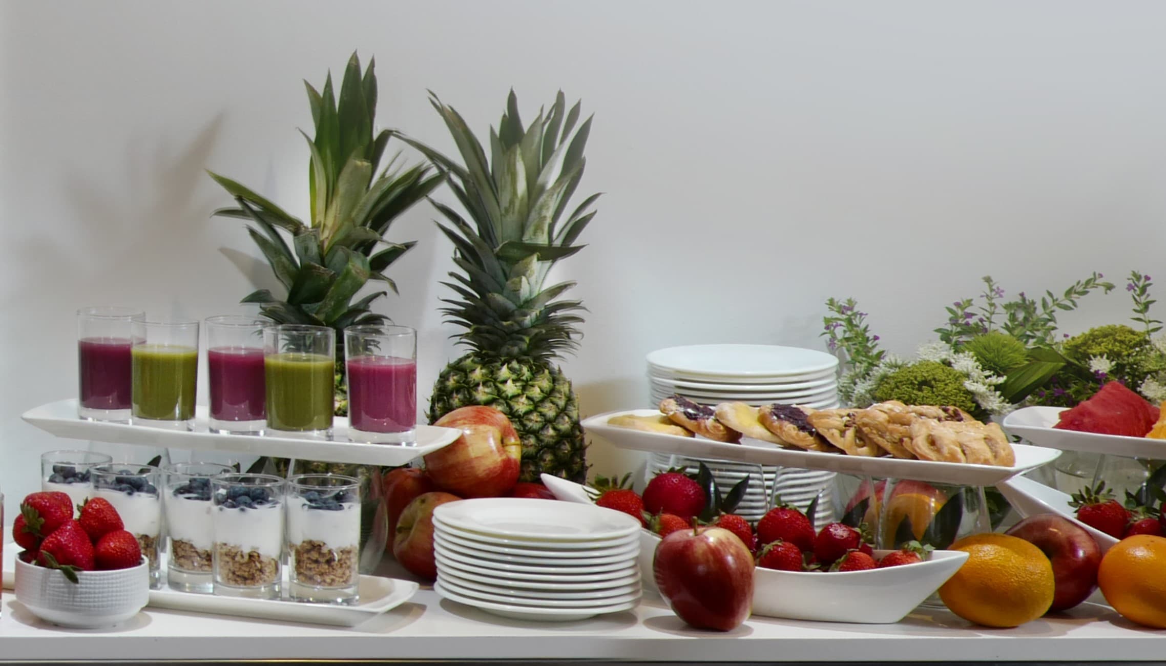A spread of fruit, fruit juices and yogurt and berries