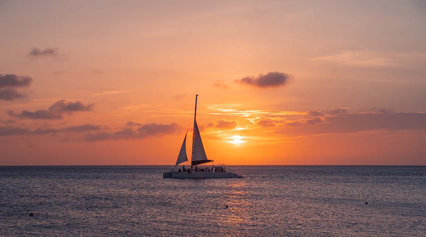 sunset at eagle beach in aruba in the caribbean with catamaran